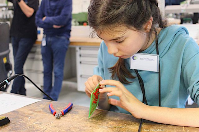 Person bastelt mit elektronischen Bauteilen