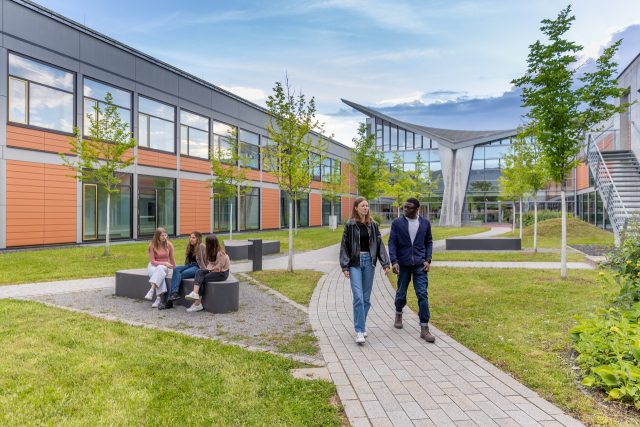 Universitätscampus mit Menschen und grüner Landschaft