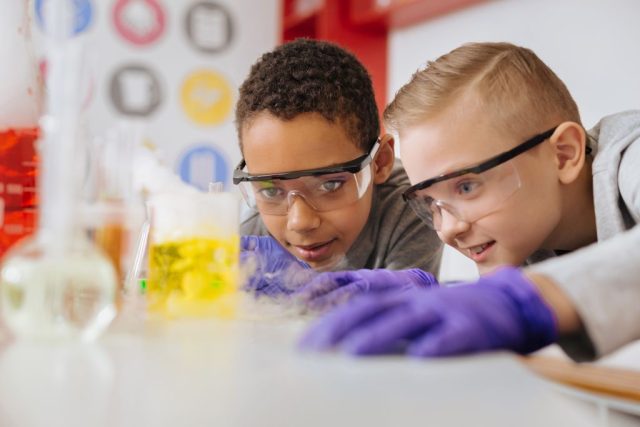 Kinder experimentieren mit bunten Flüssigkeiten im Labor.