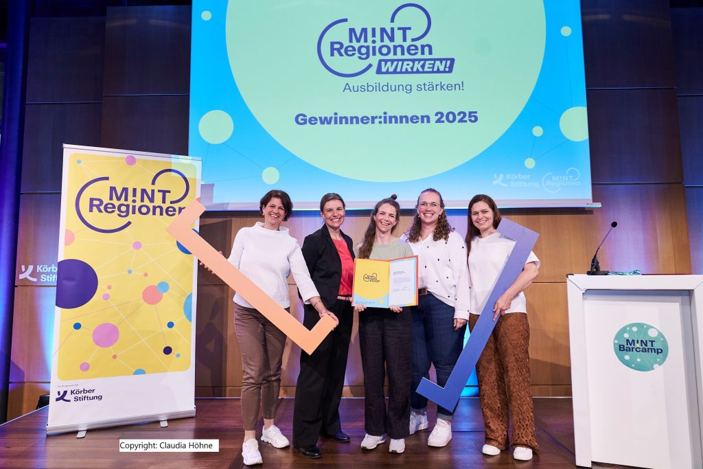 Auf der Bühne stehen die Gewinnerinnen der Auschreibung MINT-Regionen wirken 2025. Eingerahmt von den Referentinnen des MINTraum bayern.